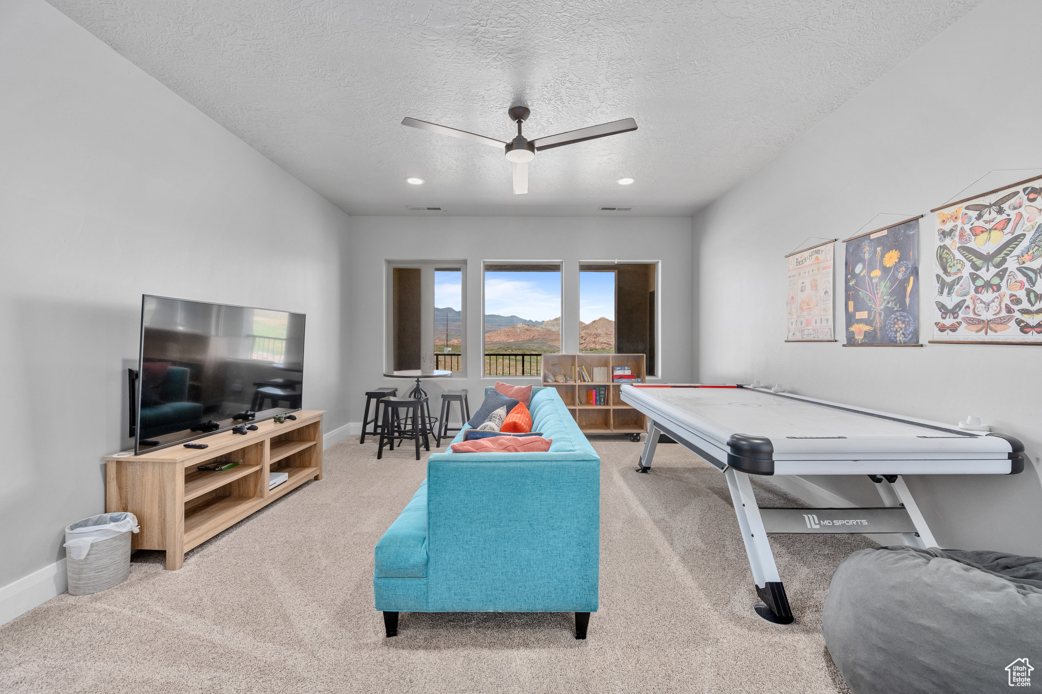 Rec room featuring a textured ceiling, carpet flooring, and ceiling fan