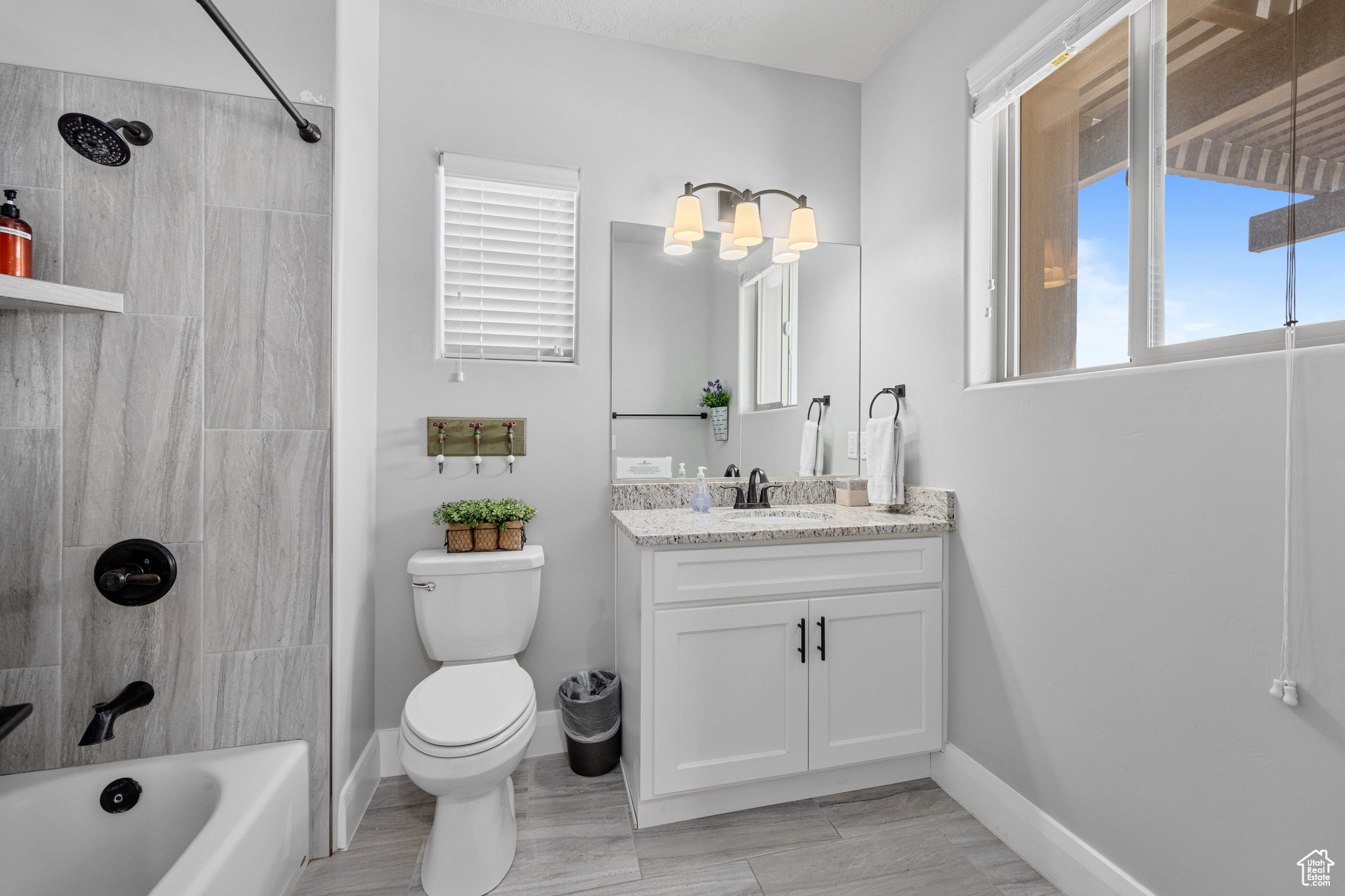 Full bathroom featuring tiled shower / bath, vanity, and toilet