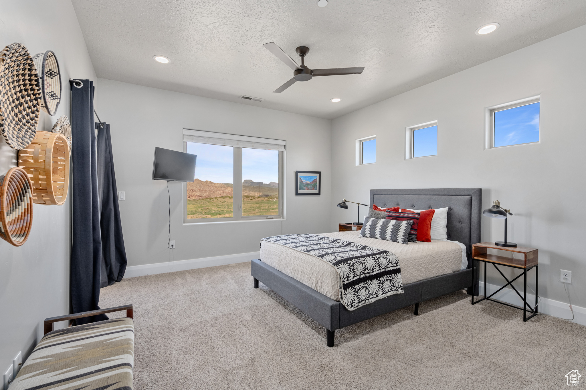 Bedroom with ceiling fan, carpet floors, and a textured ceiling