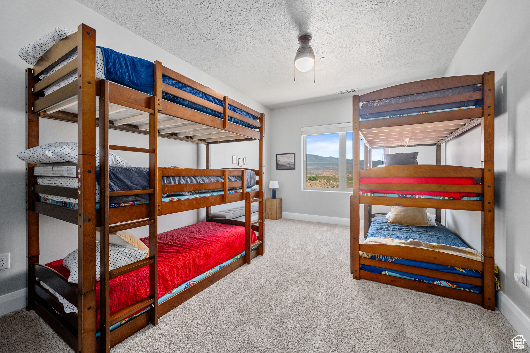 Bedroom featuring a textured ceiling, carpet flooring, and ceiling fan