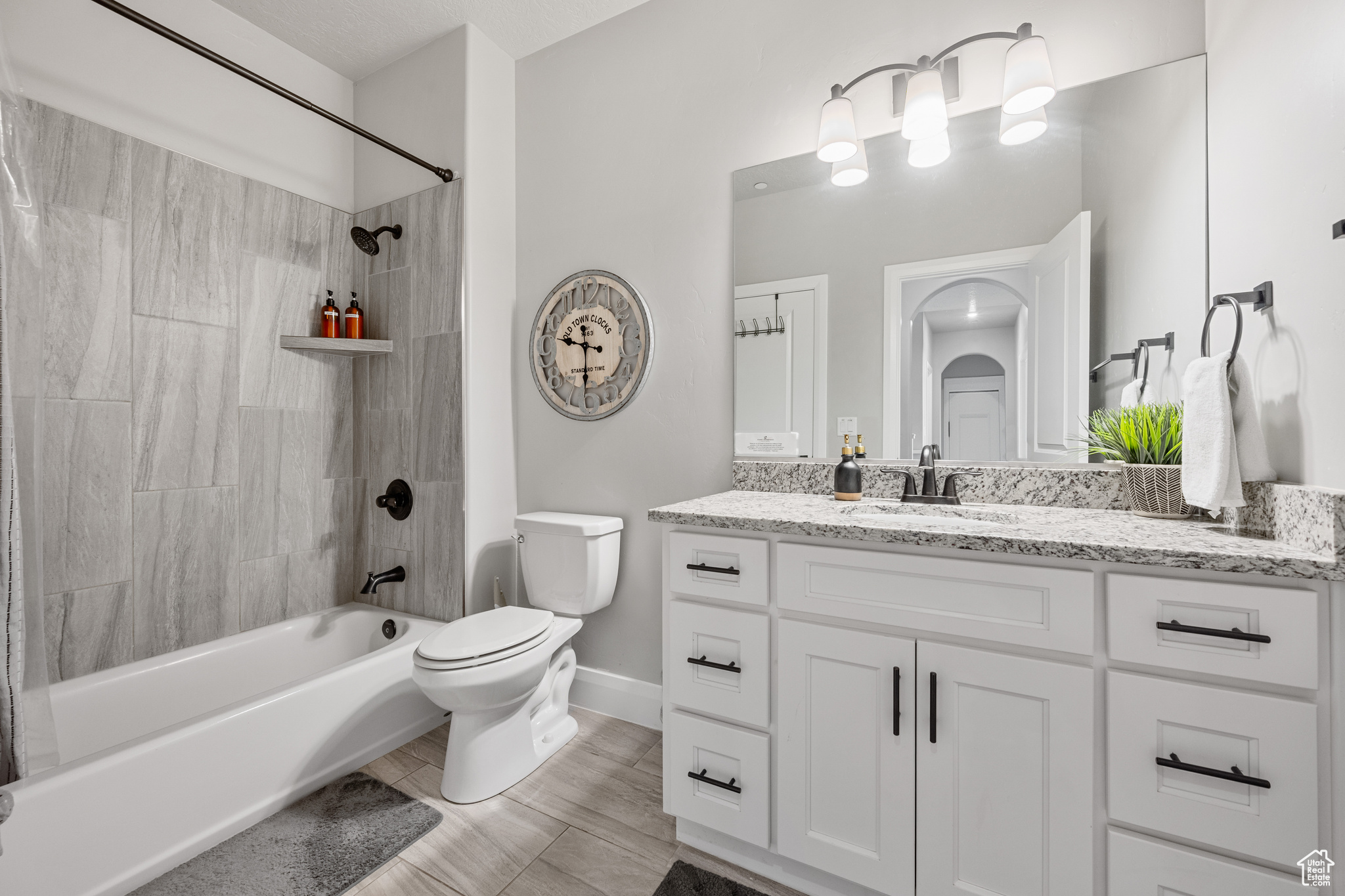 Full bathroom featuring tile flooring, toilet, vanity, and tiled shower / bath