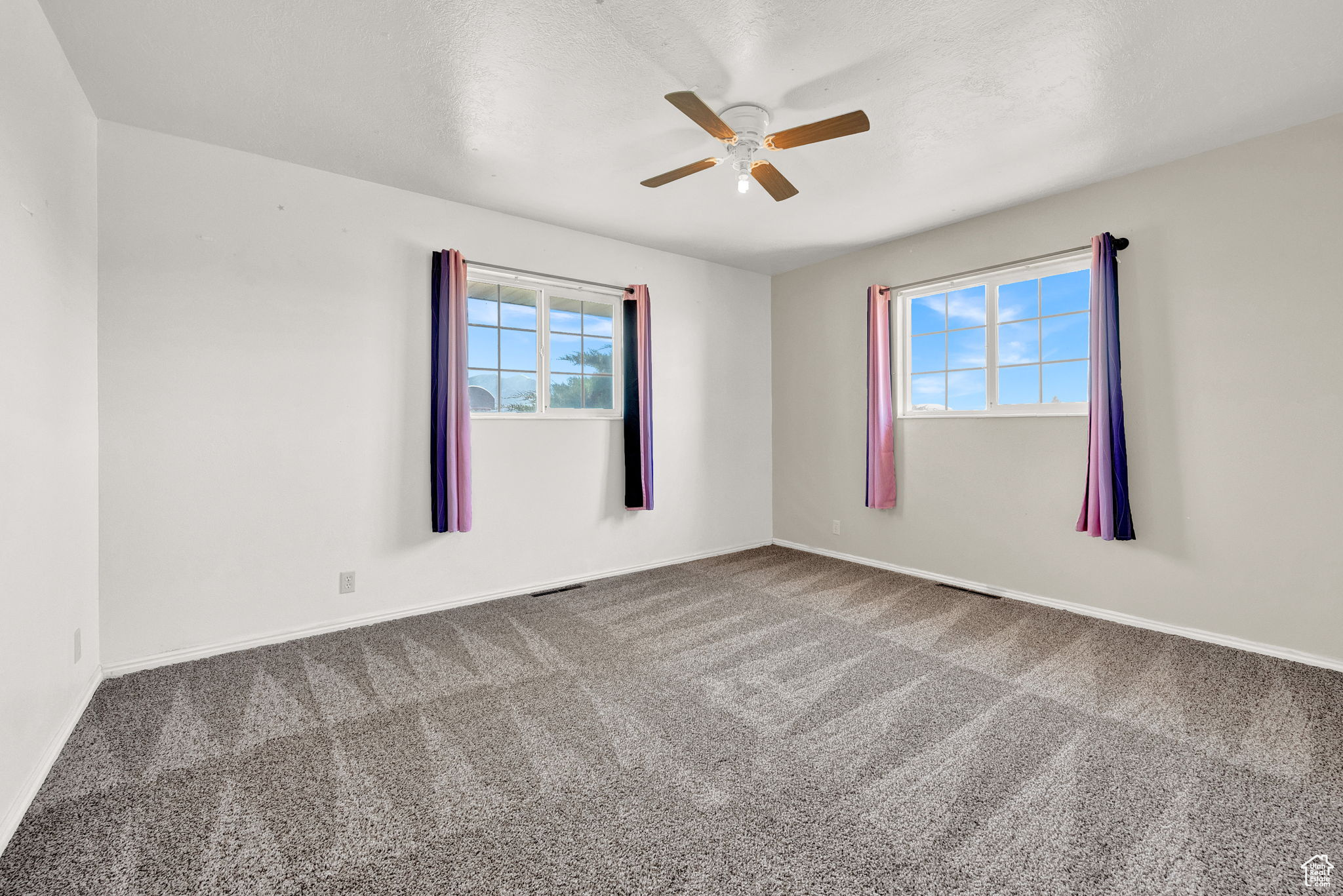 Carpeted empty room with ceiling fan