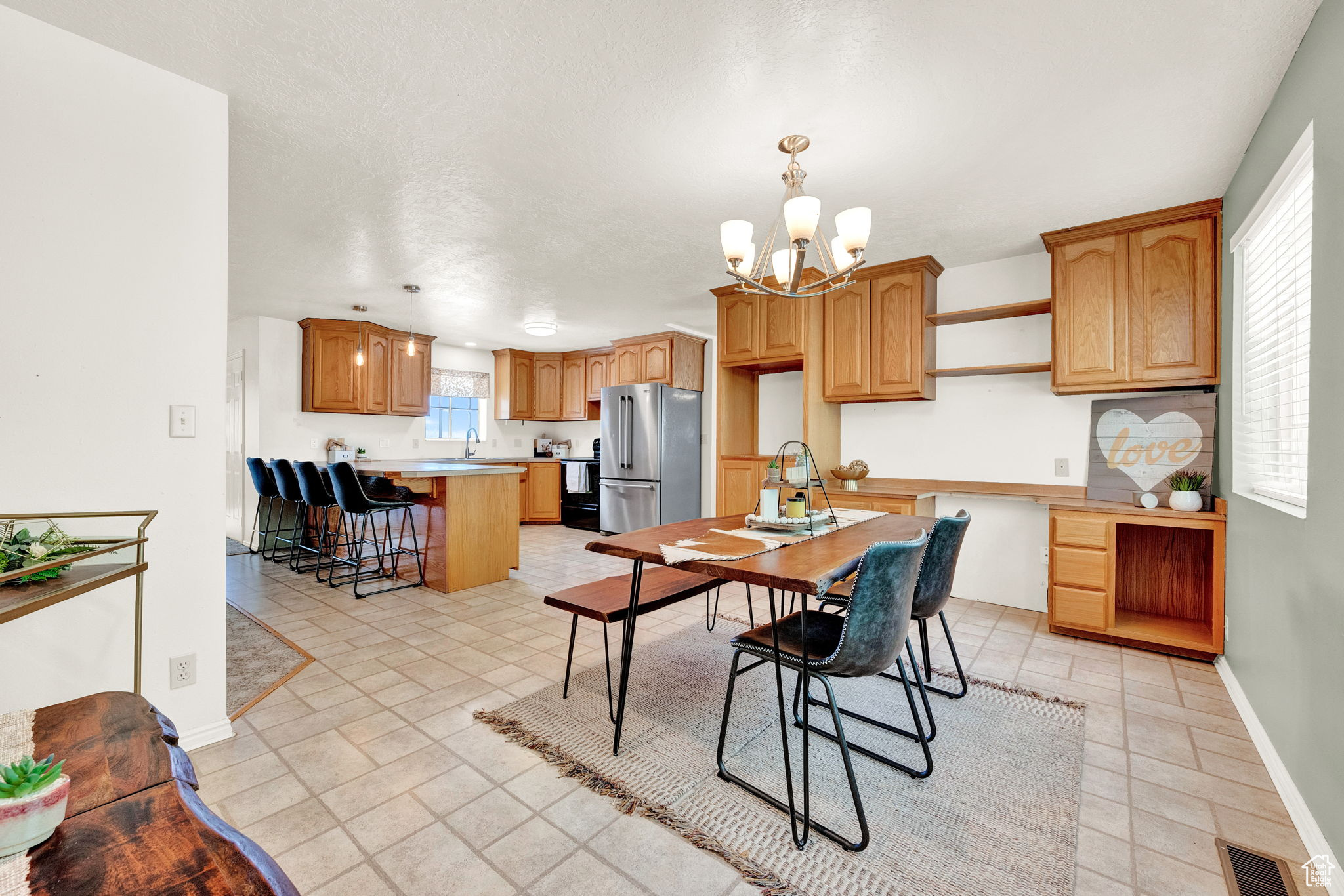 Dining area with sink, light tile patterned flooring, and an inviting chandelier