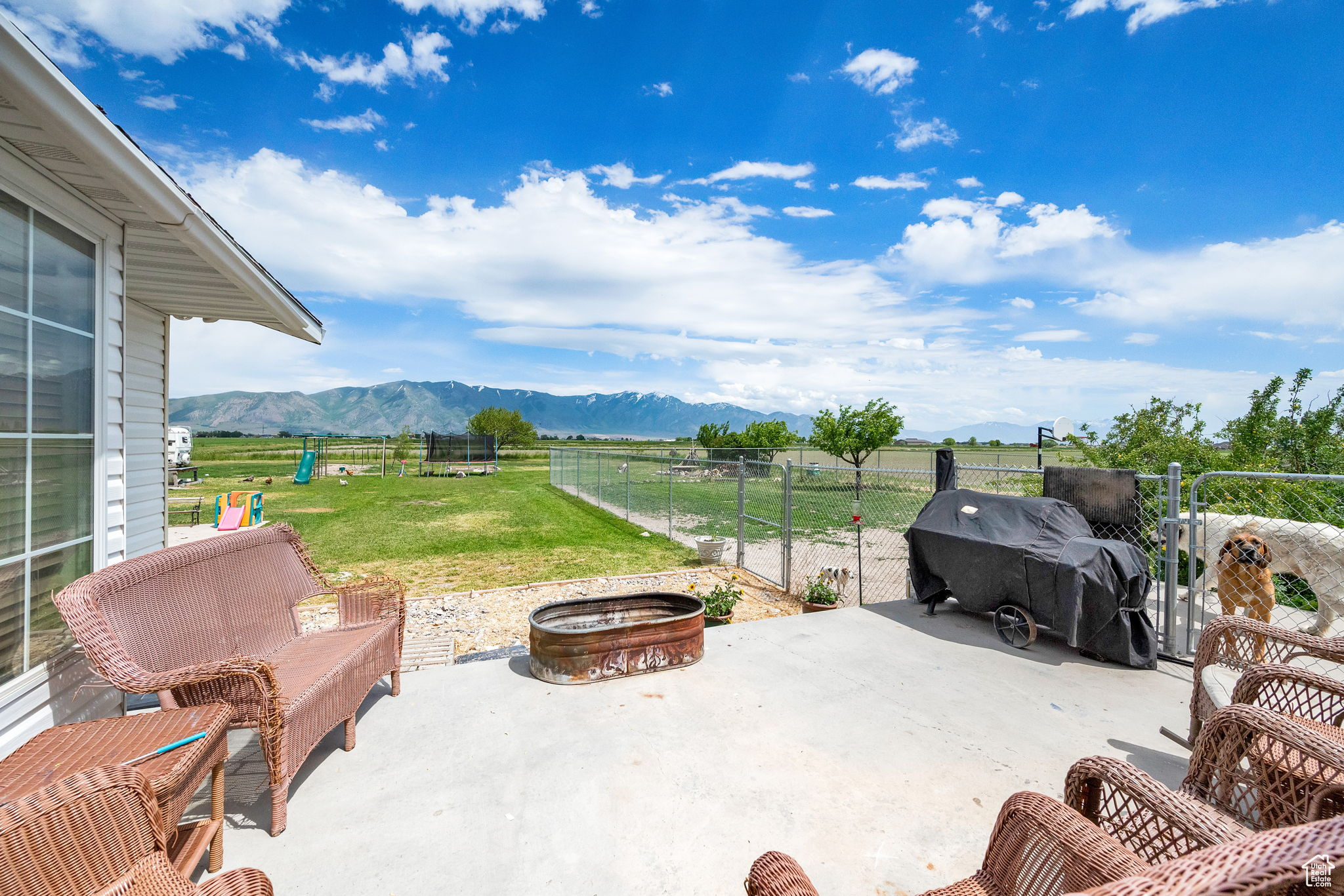 View of patio with a mountain view, an outdoor fire pit, and a rural view