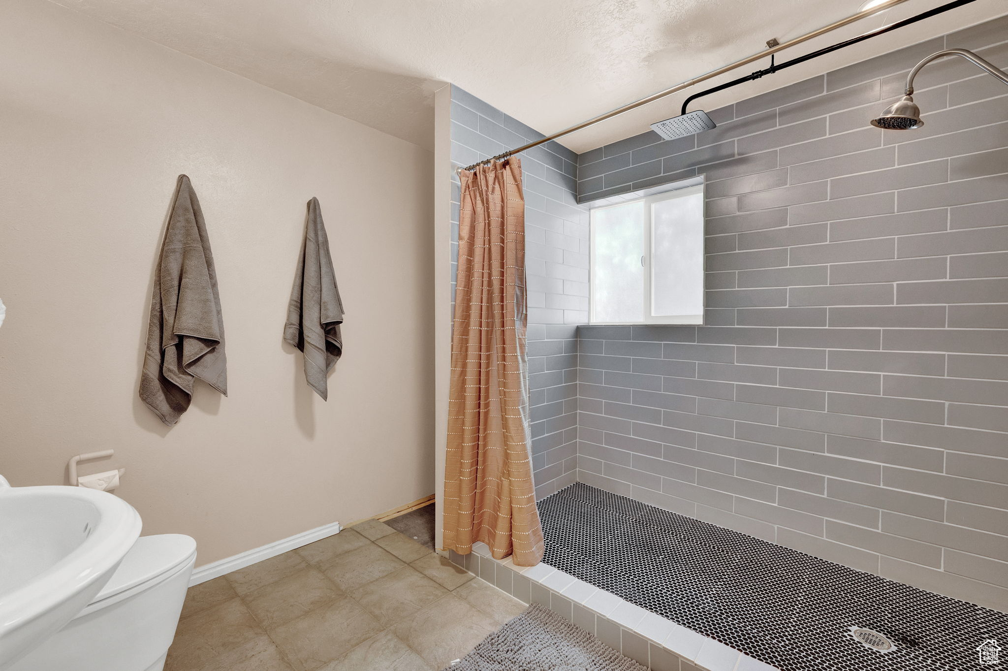 Bathroom with tile patterned flooring, toilet, and a shower with shower curtain