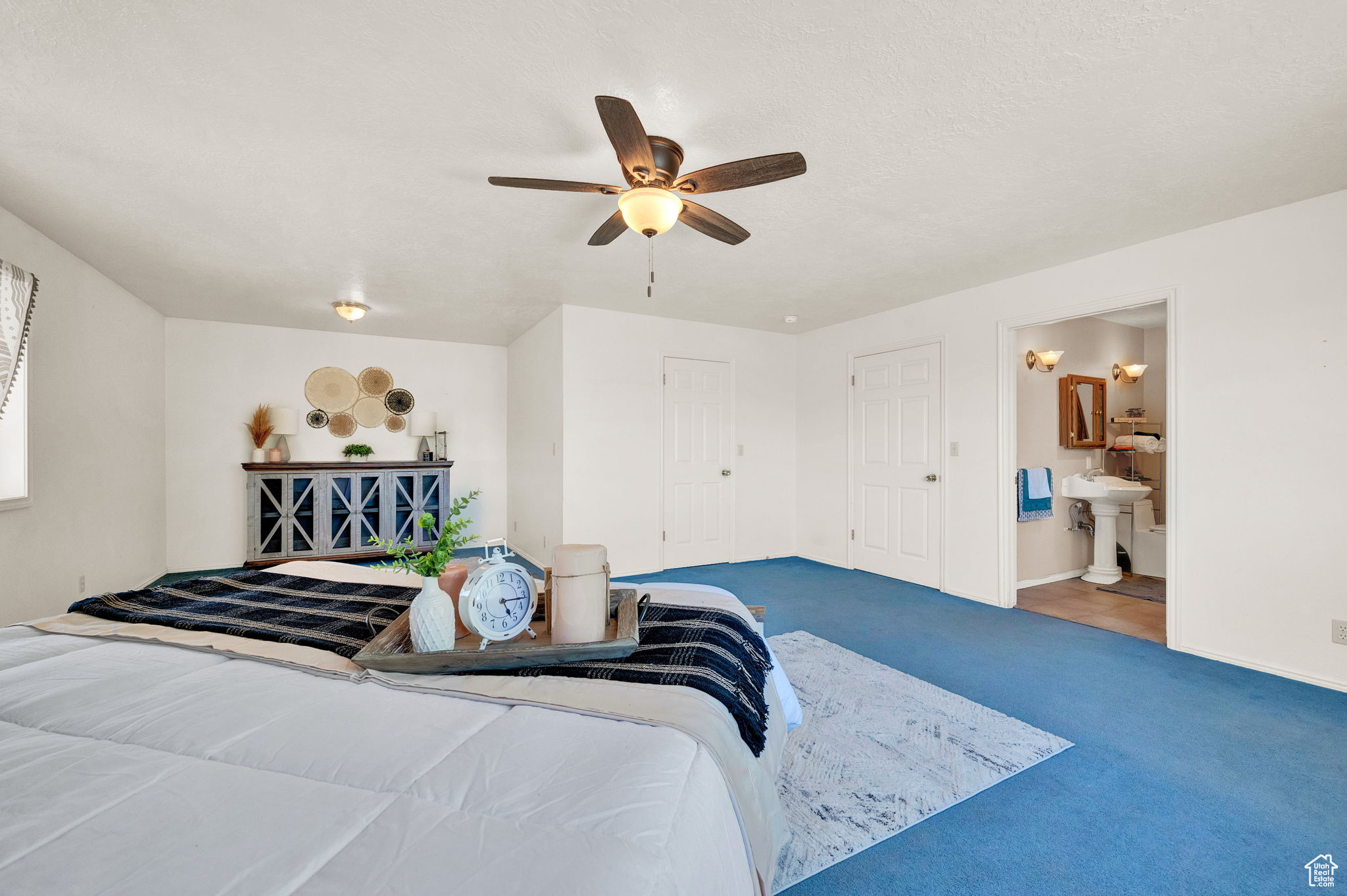 Bedroom with carpet, ensuite bathroom, and ceiling fan