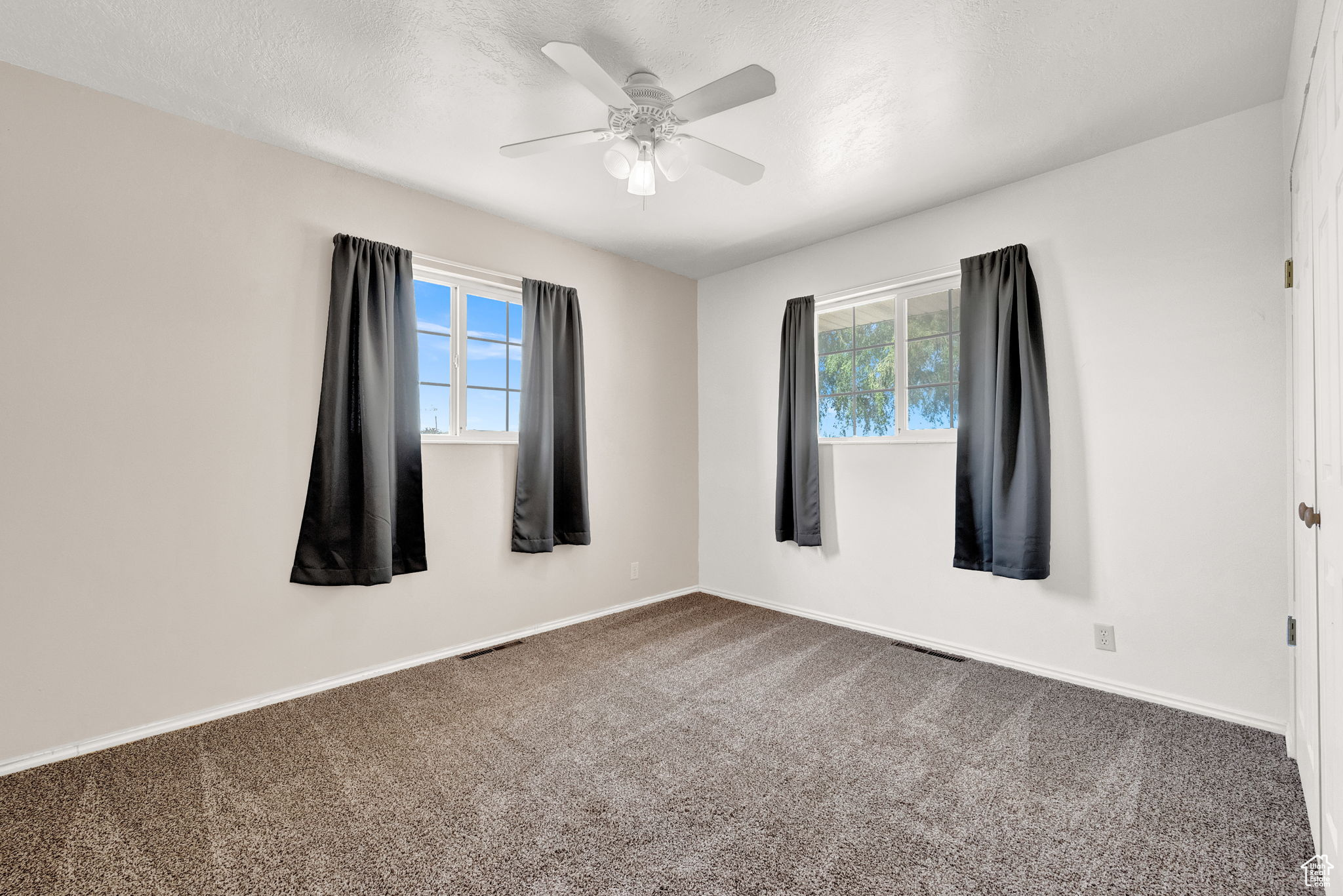 Carpeted spare room featuring ceiling fan