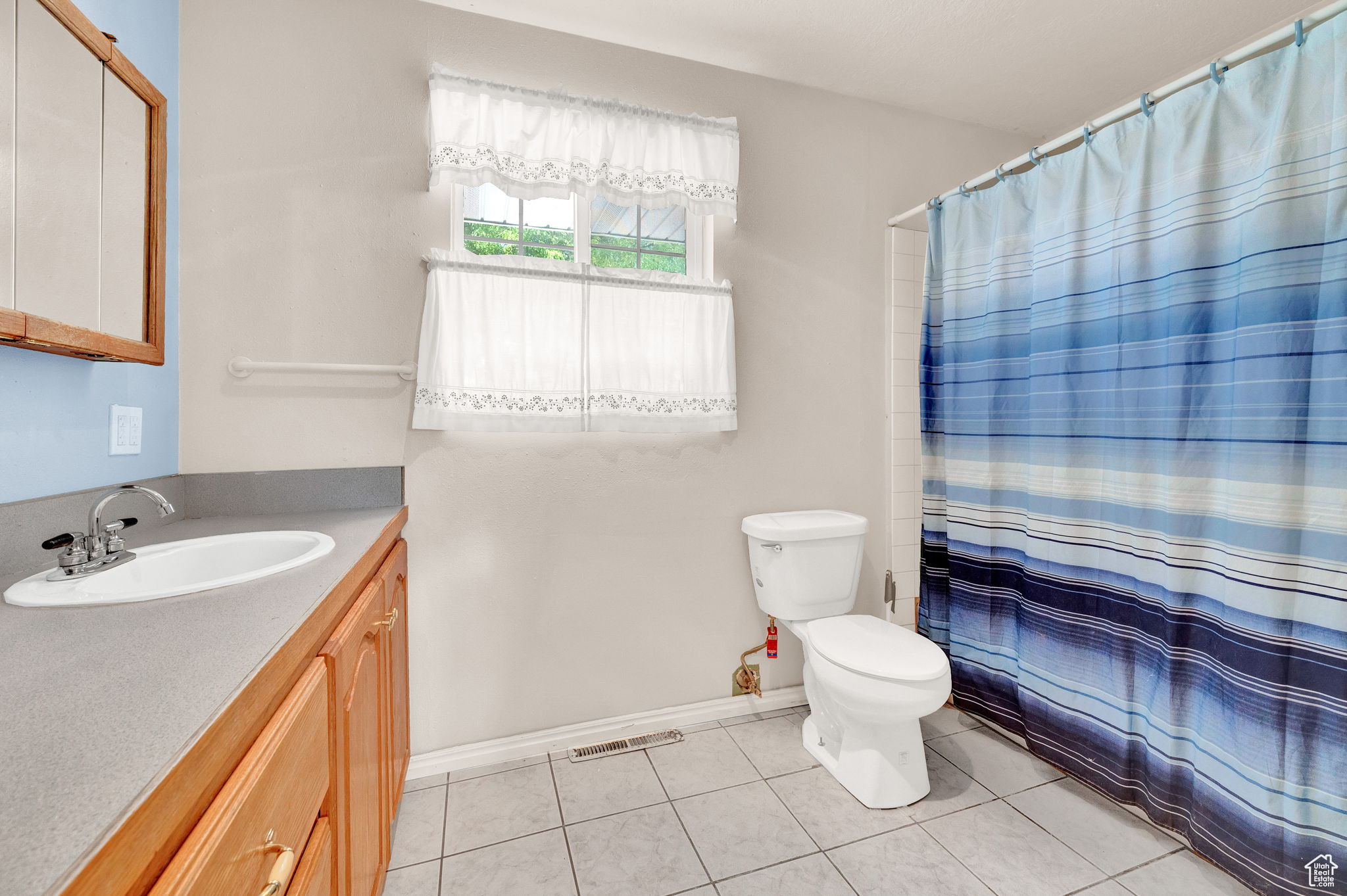 Bathroom featuring vanity, tile patterned flooring, and toilet