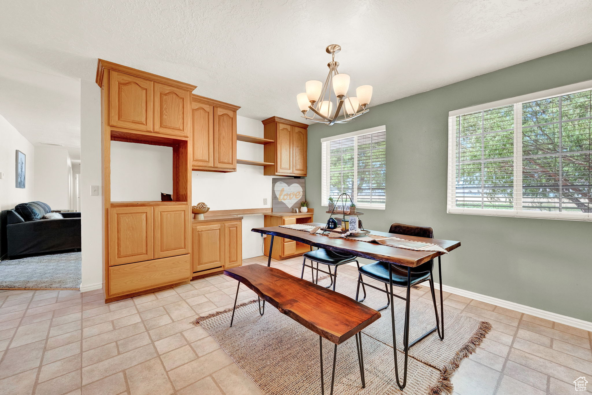 Kitchen featuring light tile patterned flooring, a chandelier, and pendant lighting