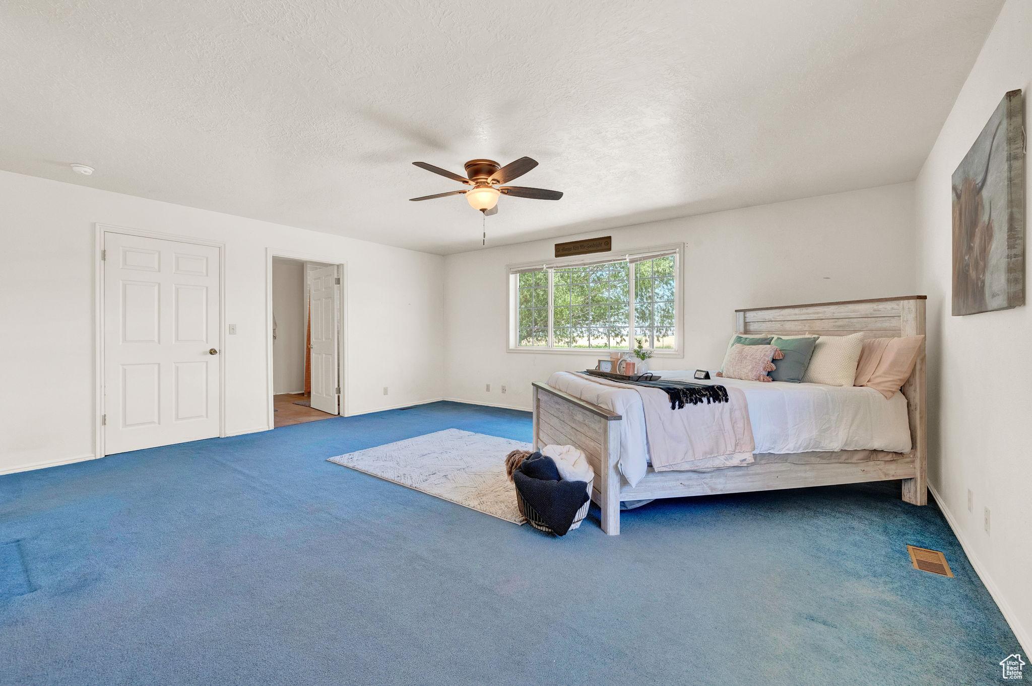 Bedroom with dark colored carpet and ceiling fan