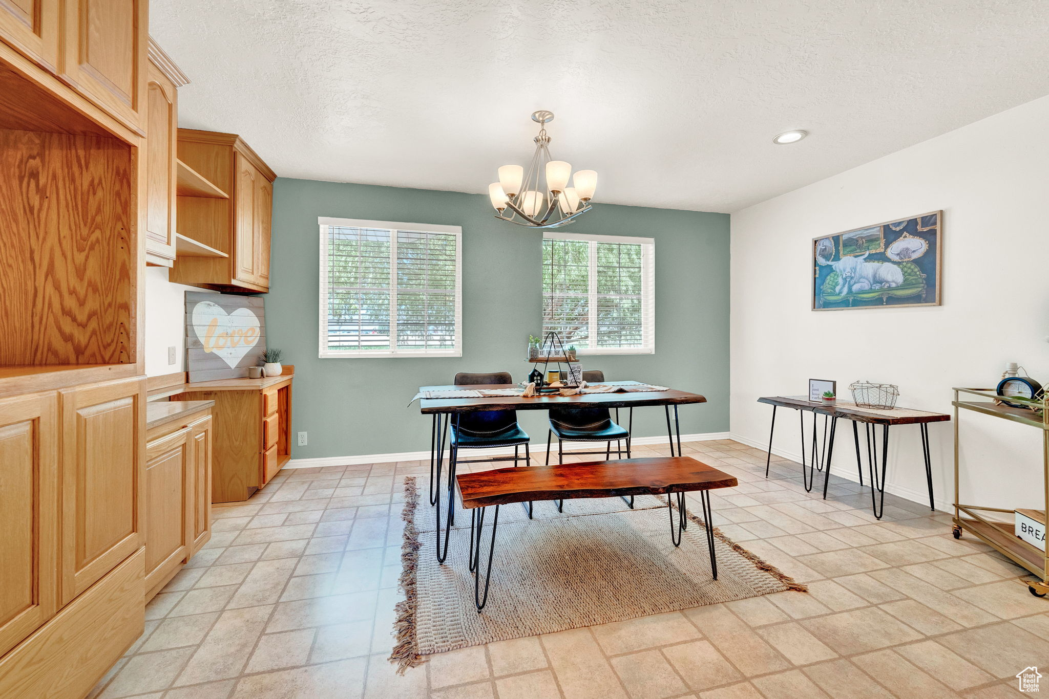 Tiled dining area featuring an inviting chandelier and a textured ceiling