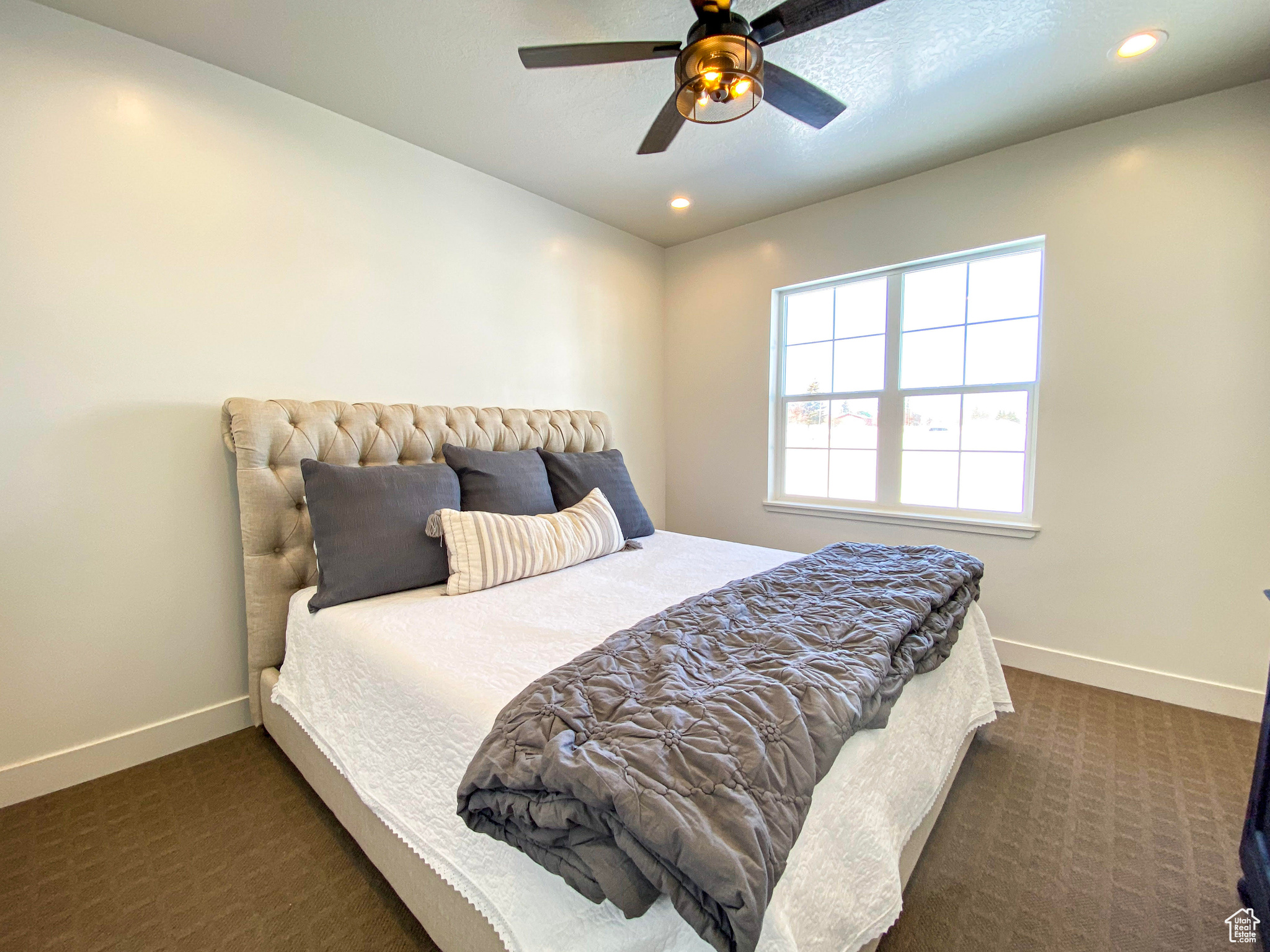 Bedroom featuring ceiling fan and dark colored carpet