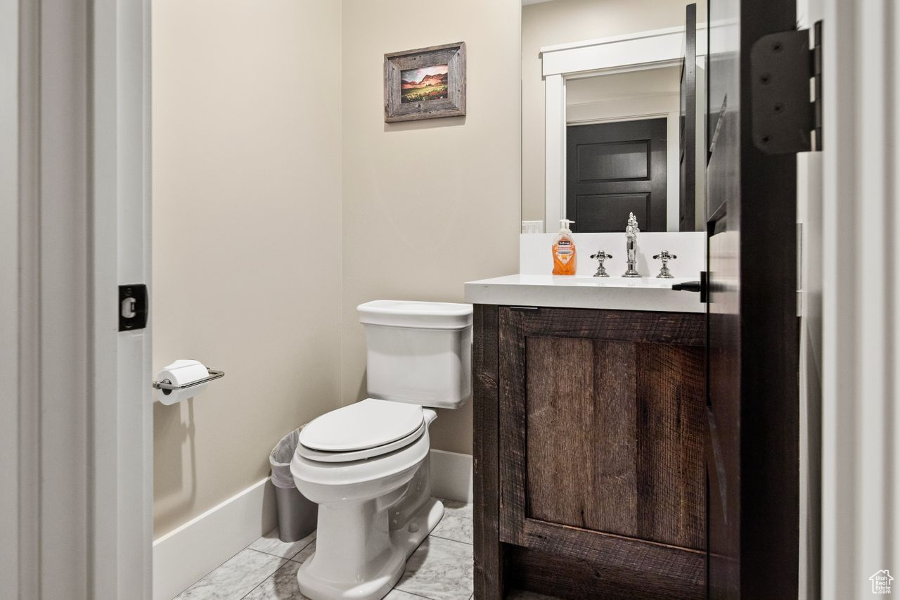 Bathroom featuring tile floors, toilet, and vanity