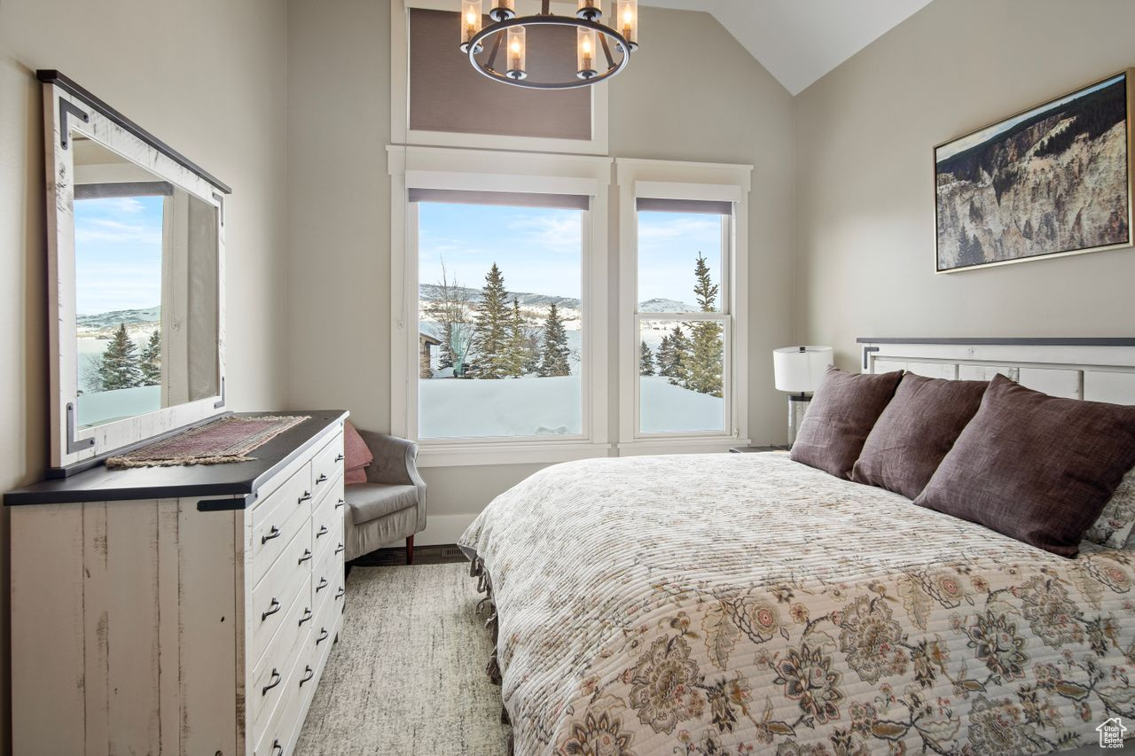 Bedroom with a chandelier and vaulted ceiling