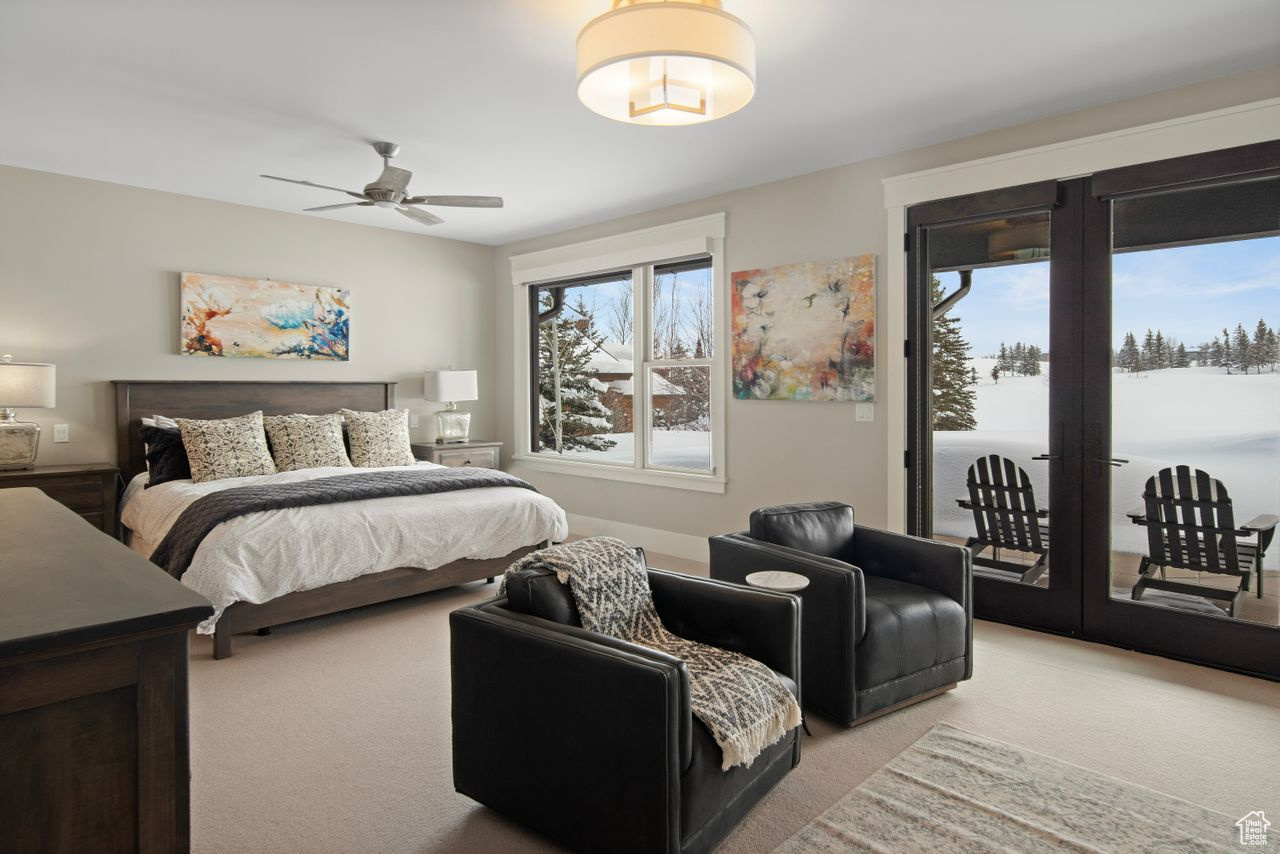 Carpeted bedroom featuring french doors, ceiling fan, and access to exterior