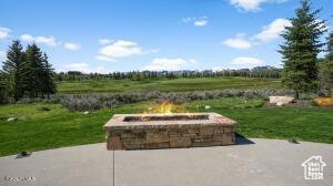 View of patio / terrace with an outdoor fire pit and a rural view