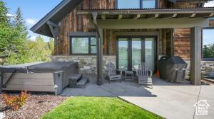 Back of house featuring a patio and a hot tub