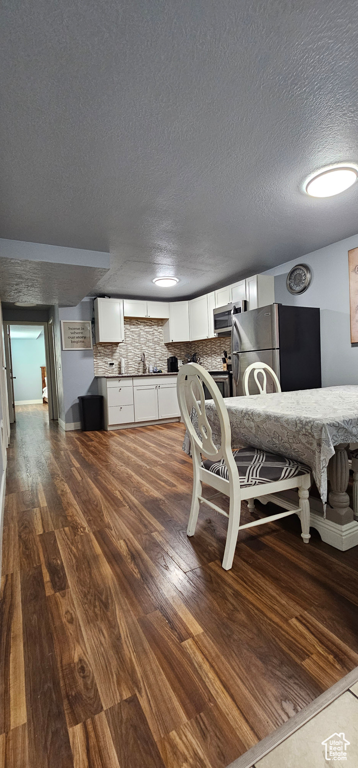 Dining space featuring hardwood / wood-style flooring and a textured ceiling