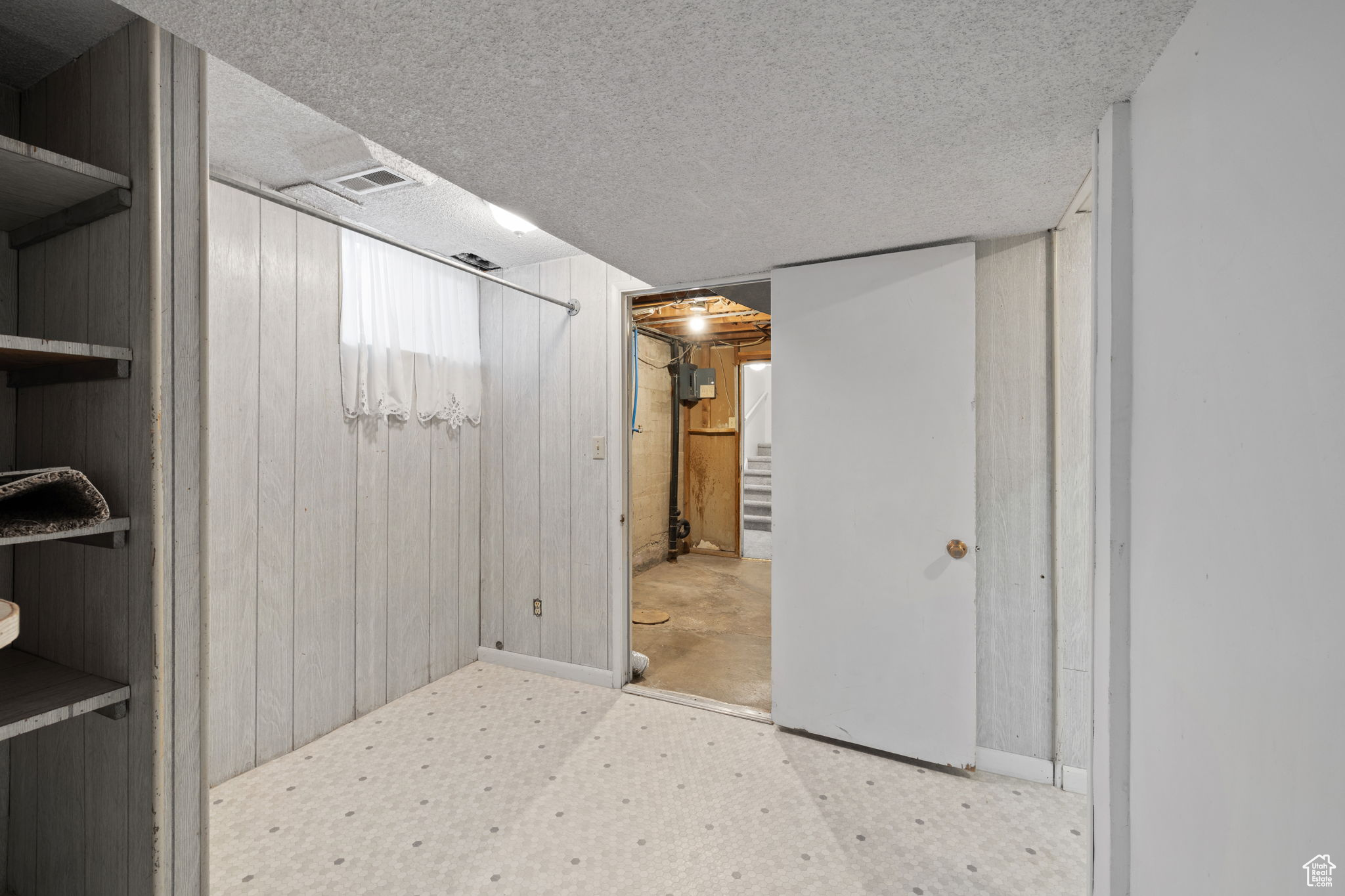 Basement featuring wood walls and a textured ceiling