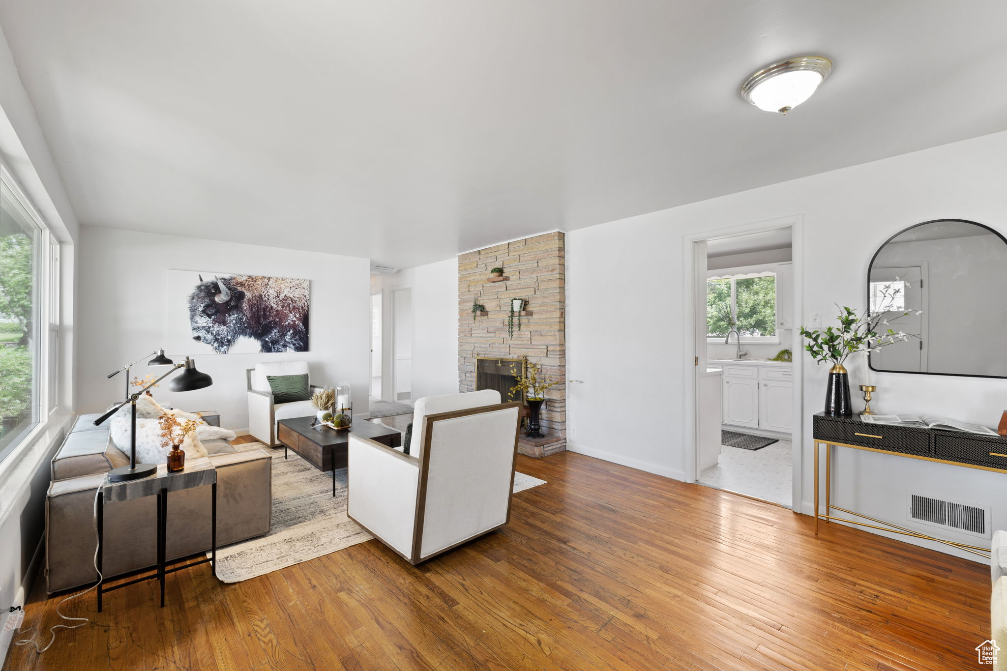 Living room with sink, hardwood / wood-style flooring, and a fireplace