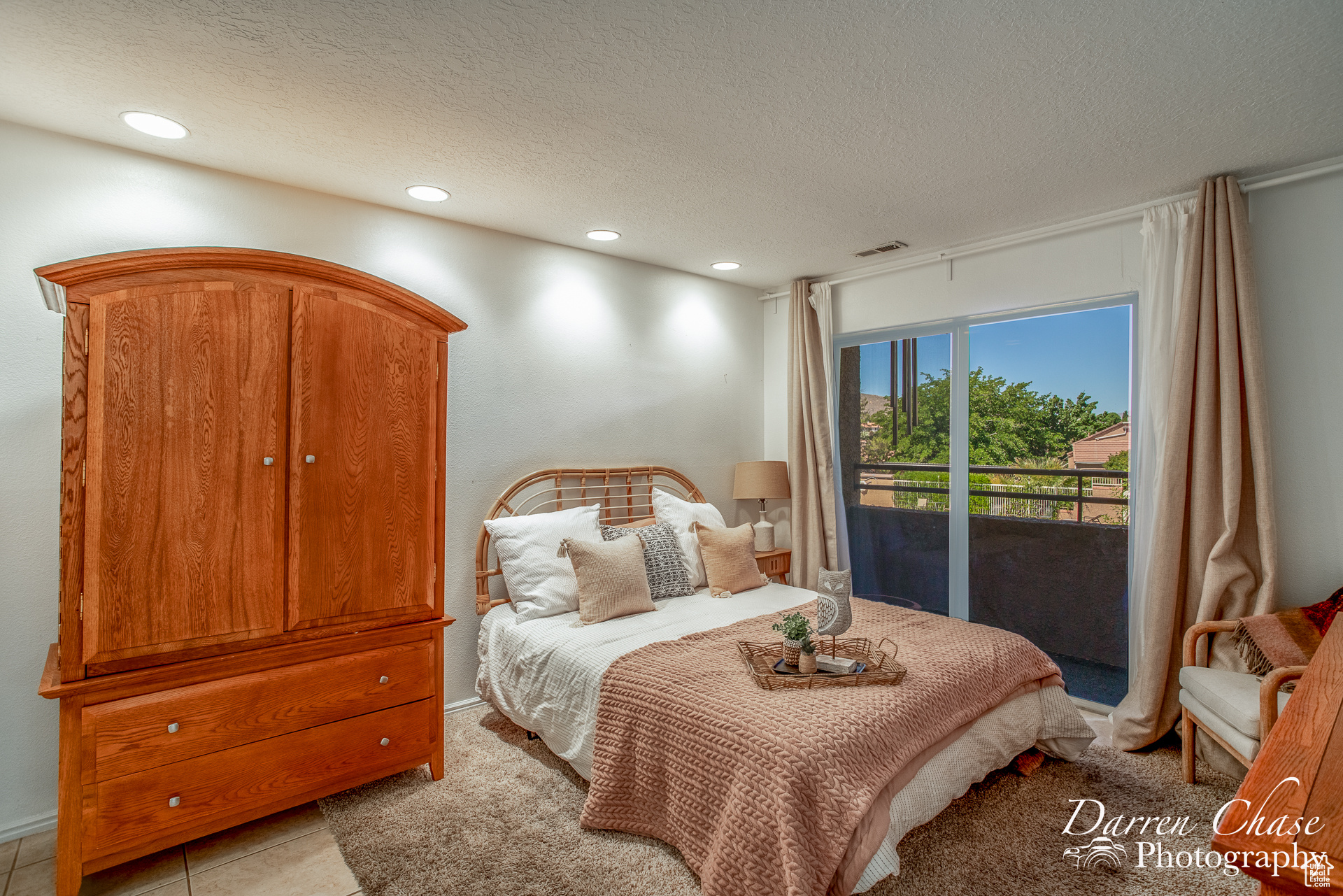 Large Primary bedroom with balcony with views to pool and greenery