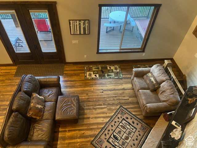 Living room with french doors, a wealth of natural light, and dark wood-type flooring