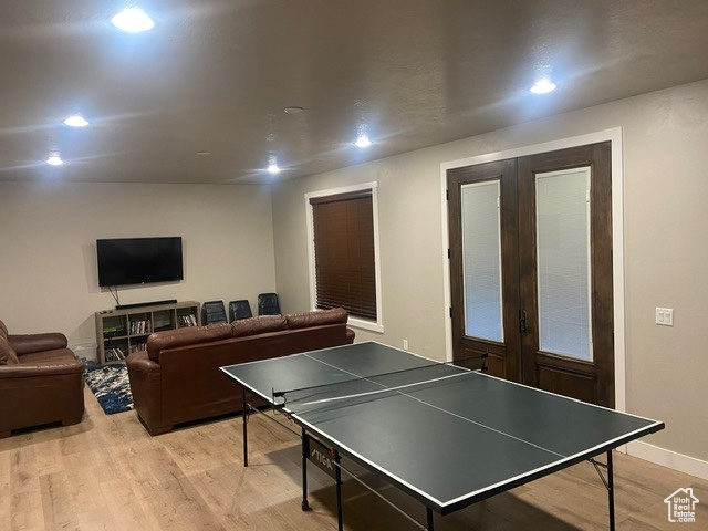 DOWN STAIRS Game room with light hardwood / wood-style flooring and french doors