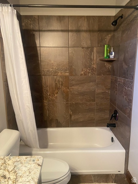 DOWNSTAIRS Full bathroom with tile flooring, shower / tub combo with curtain, toilet, and vanity