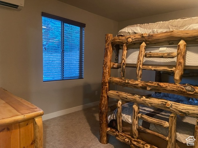 DOWNSTAIRS Bedroom featuring carpet flooring and an AC wall unit