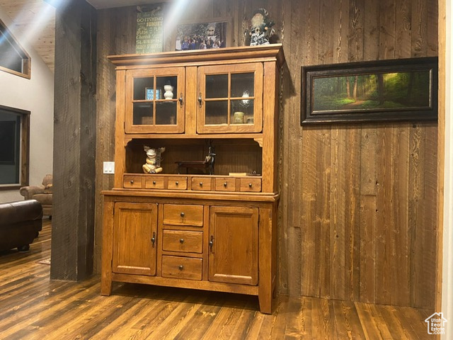 Bar with wooden walls and dark wood-type flooring