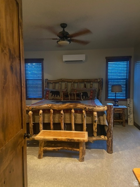 MASTER BEDROOM Carpeted bedroom featuring a wall unit AC and ceiling fan