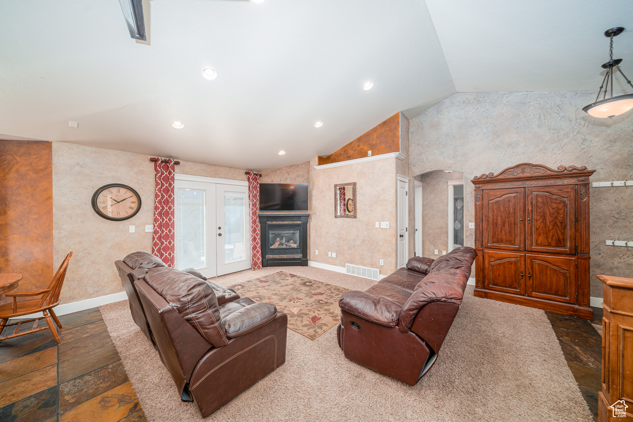 Living room with tile floors, french doors, and lofted ceiling