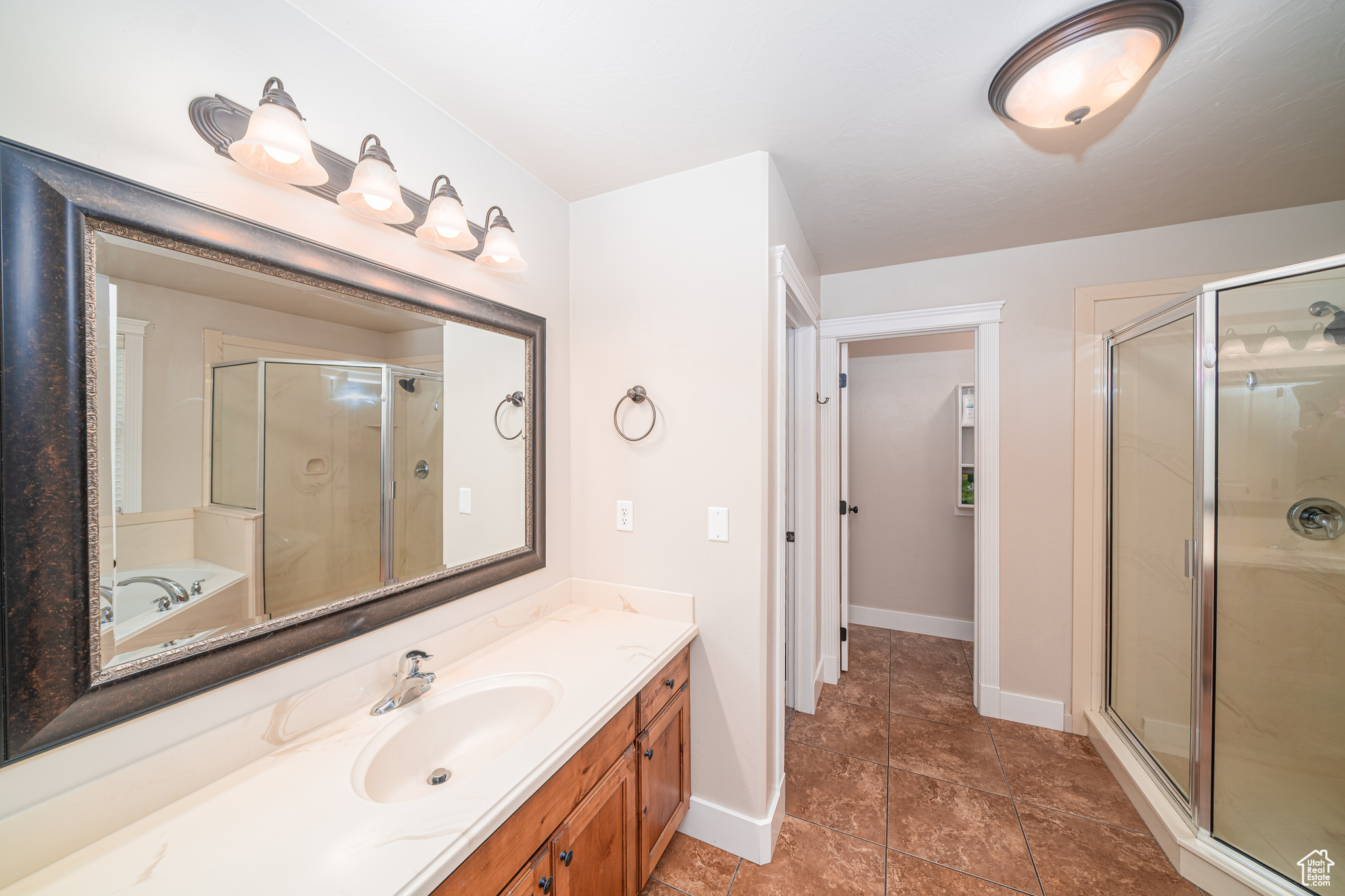 Bathroom with separate shower and tub, tile floors, and large vanity