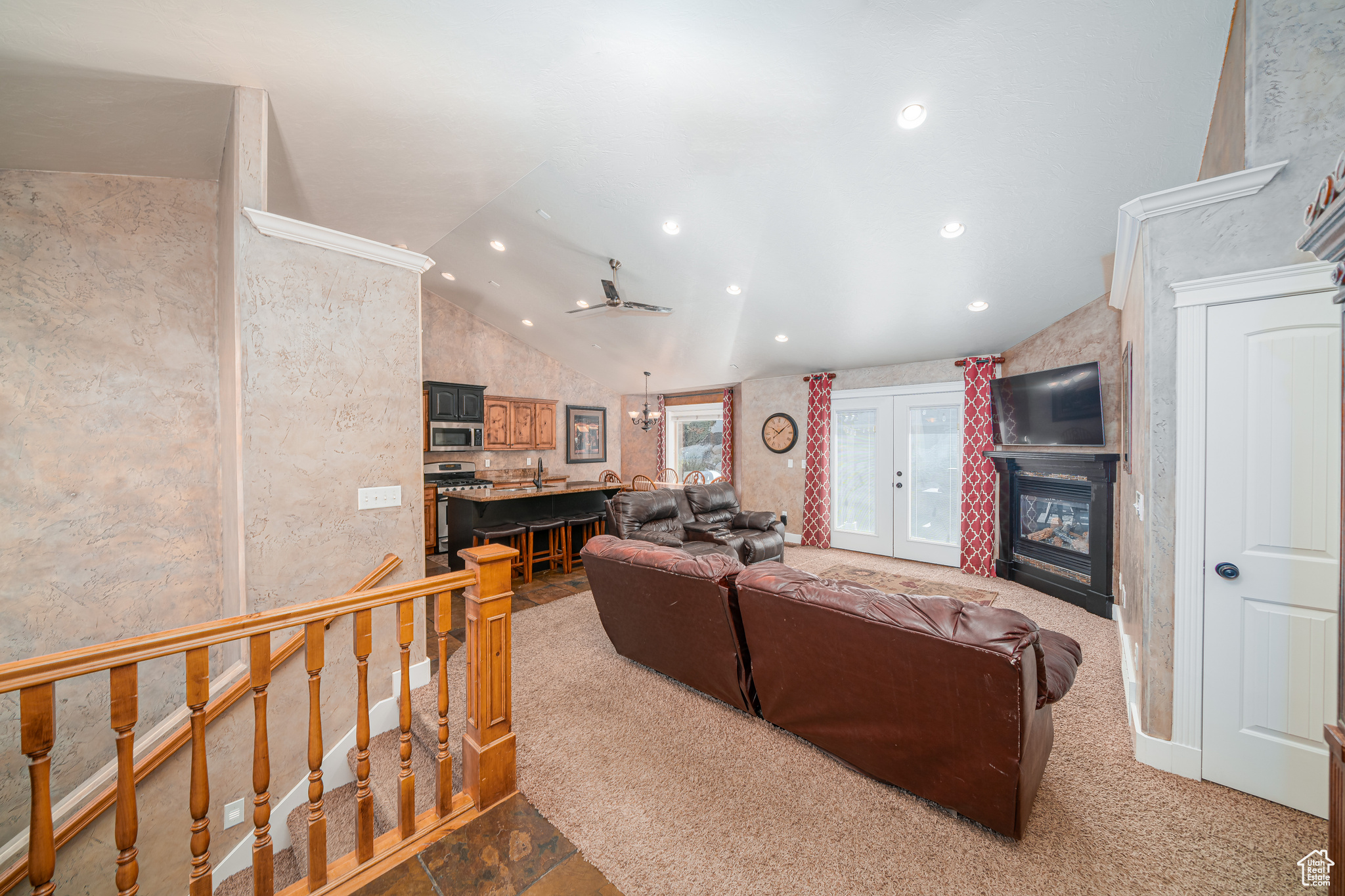 Living room featuring carpet, french doors, and lofted ceiling