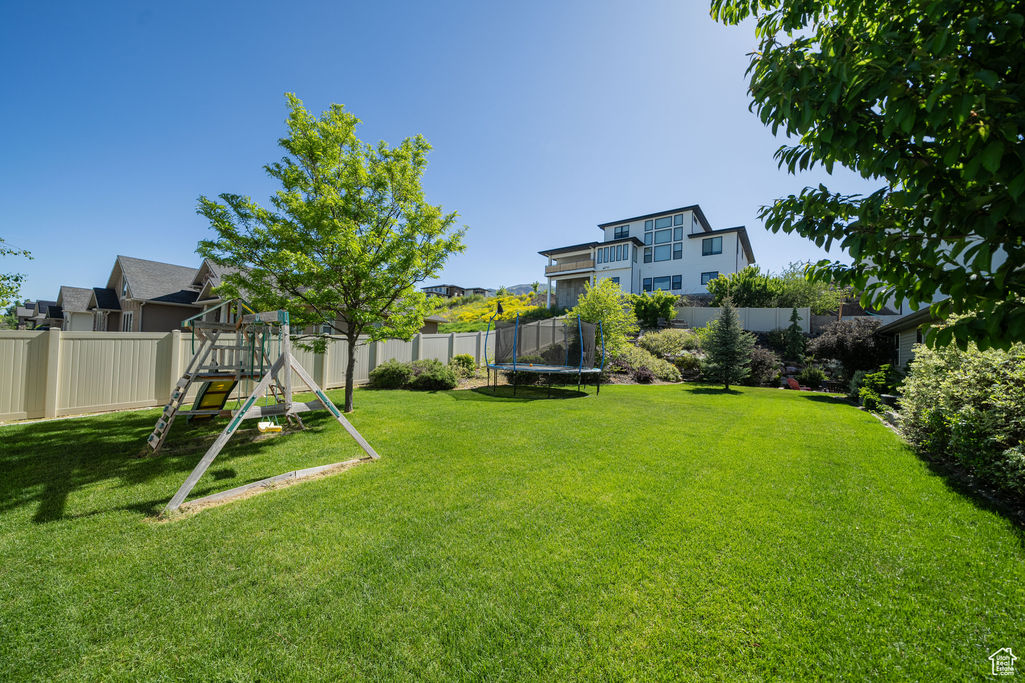 View of yard featuring a playground and a trampoline