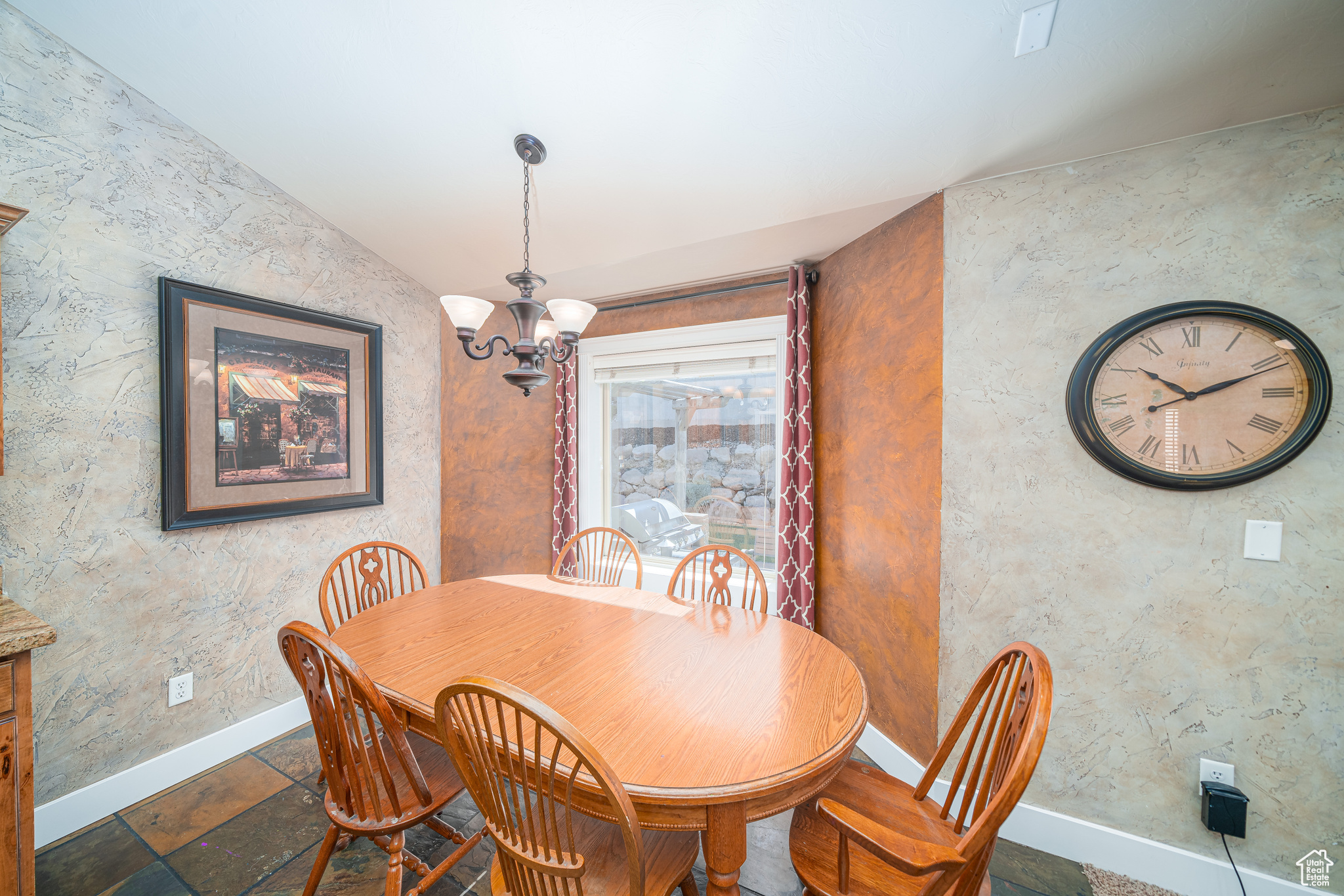 Tiled dining area with a notable chandelier and lofted ceiling