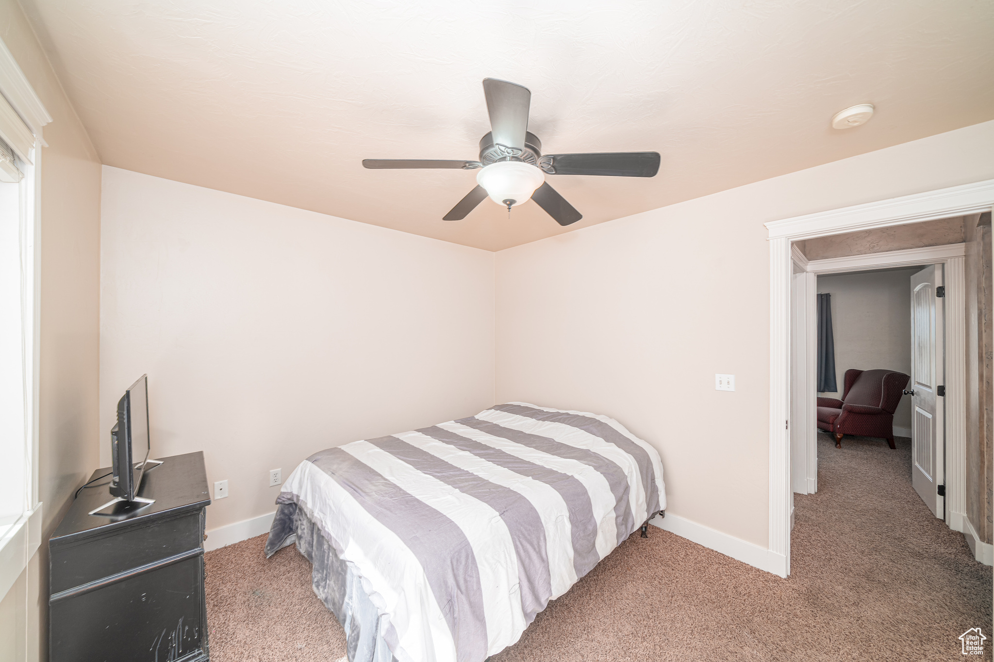 Carpeted bedroom featuring ceiling fan