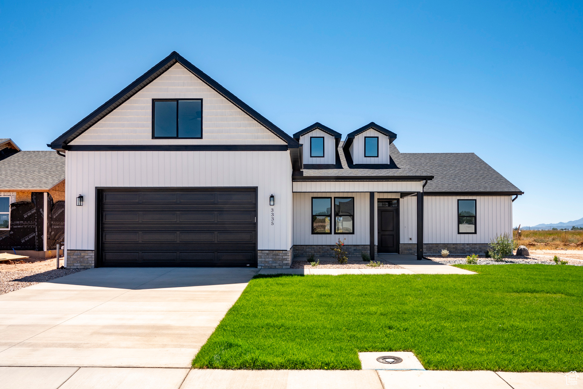 Modern inspired farmhouse featuring a garage and a front yard