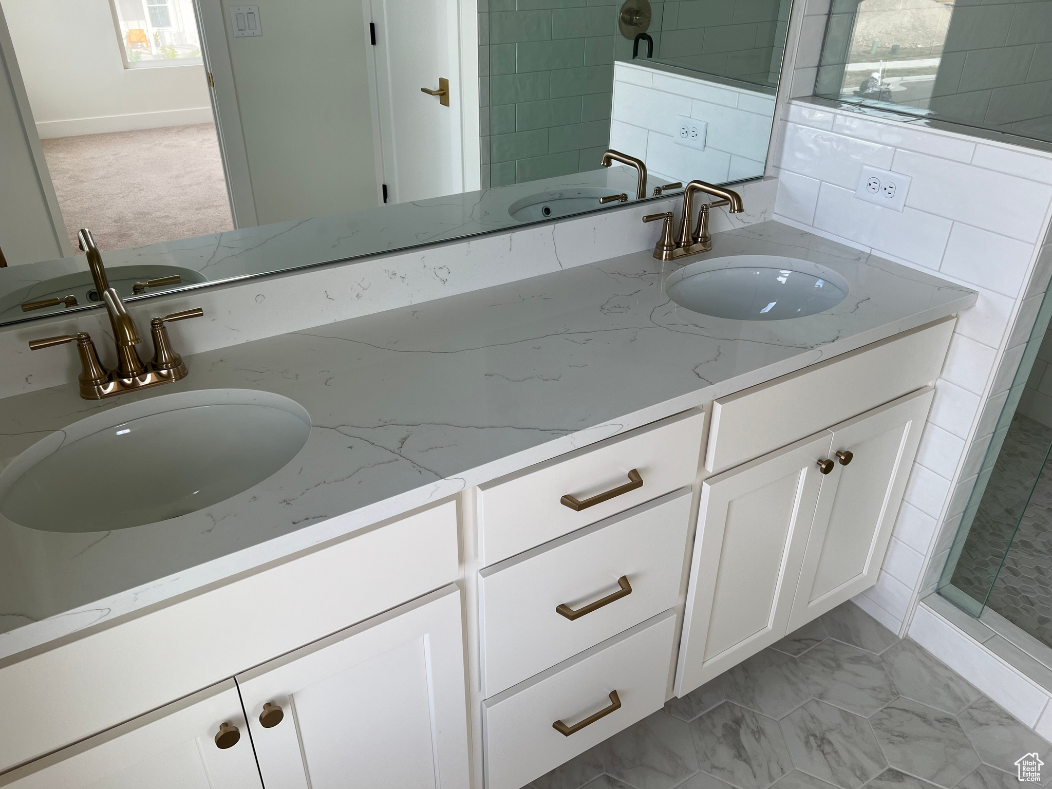 Bathroom featuring a shower, vanity, and decorative backsplash