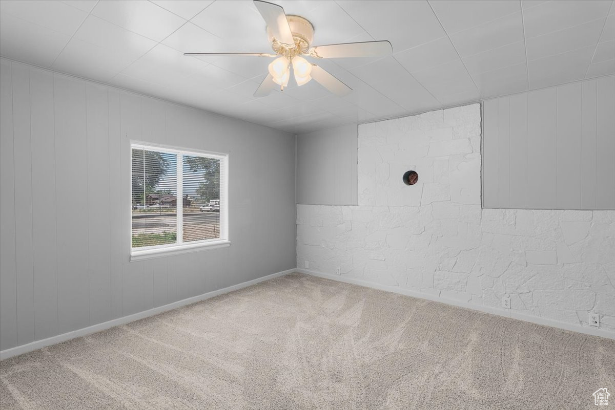 Spare room featuring light carpet and ceiling fan