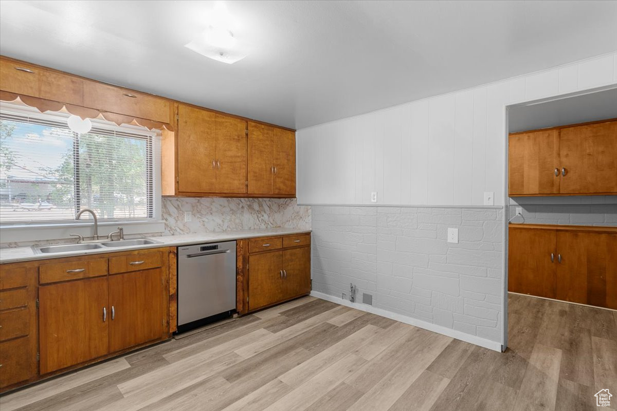 Kitchen featuring light hardwood / wood-style floors, tasteful backsplash, sink, and stainless steel dishwasher