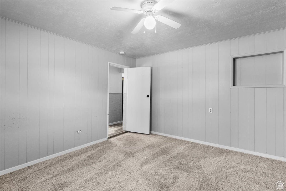 Unfurnished bedroom featuring carpet floors, a textured ceiling, and ceiling fan