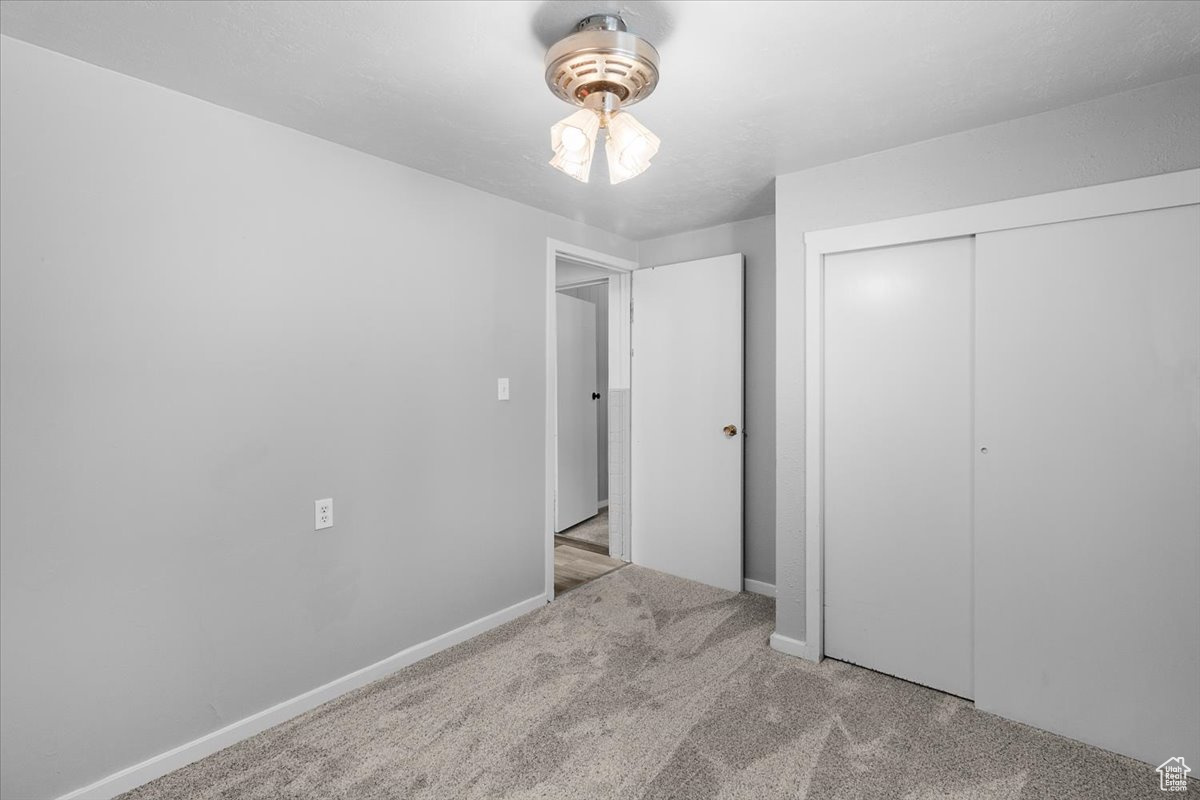 Unfurnished bedroom featuring a closet and light colored carpet