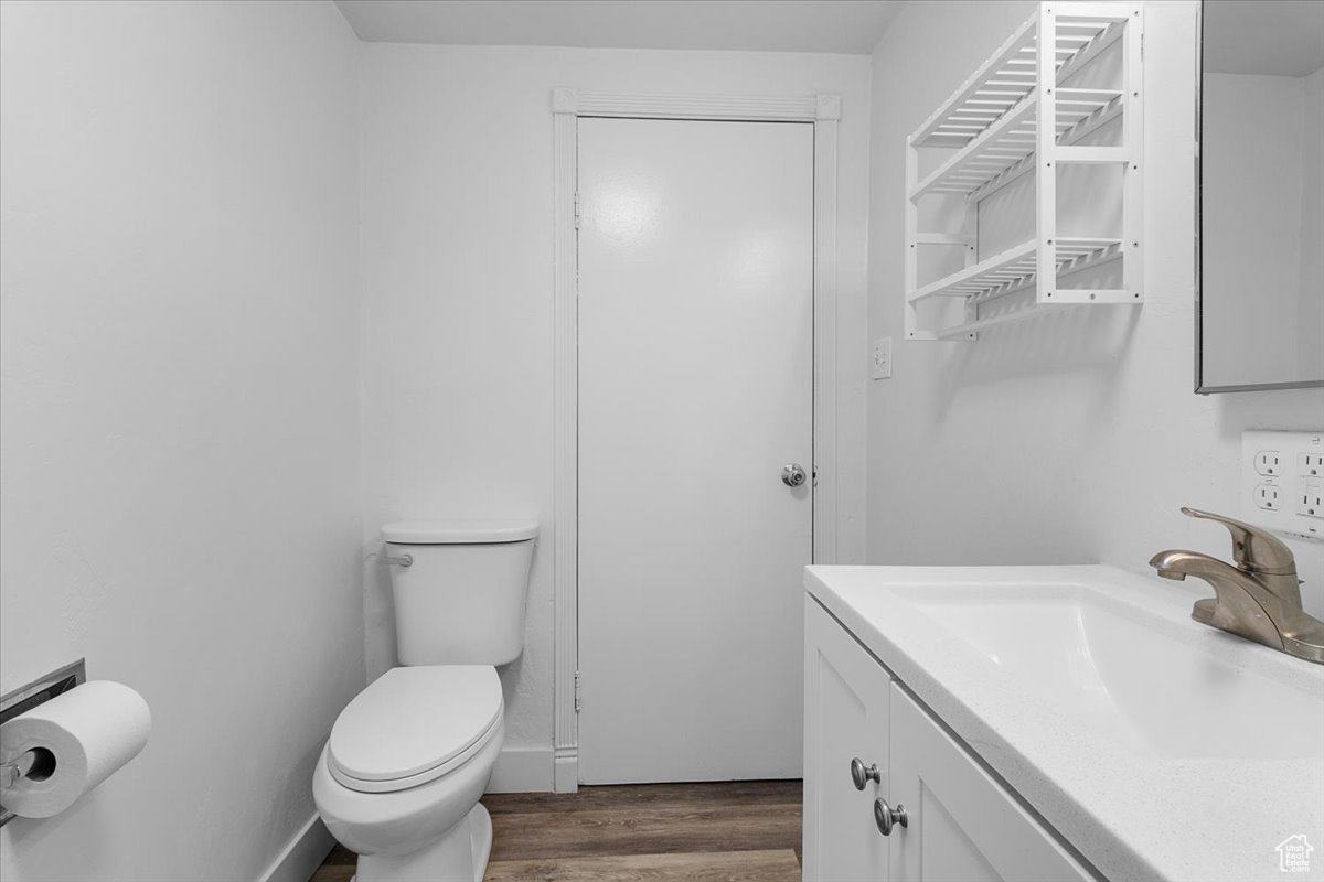 Bathroom with wood-type flooring, toilet, and vanity