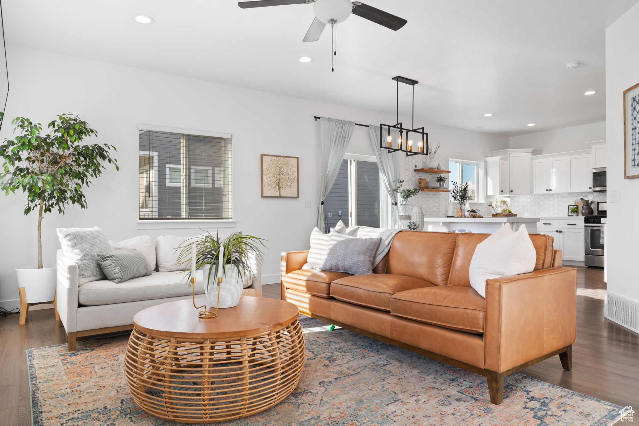 Living room featuring dark hardwood / wood-style floors and ceiling fan with notable chandelier