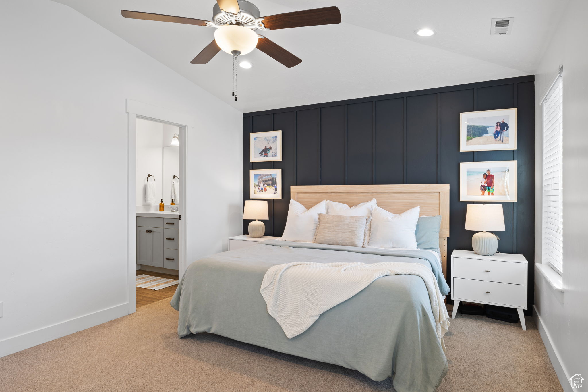 Bedroom with ceiling fan, connected bathroom, lofted ceiling, and light carpet