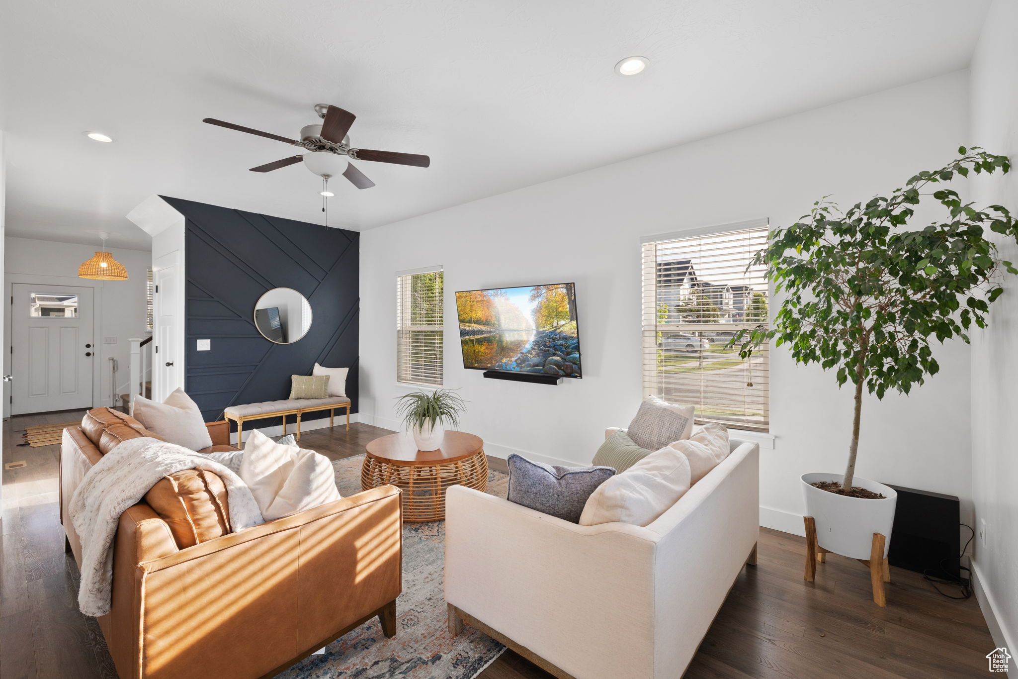 Living room featuring ceiling fan and dark hardwood / wood-style flooring