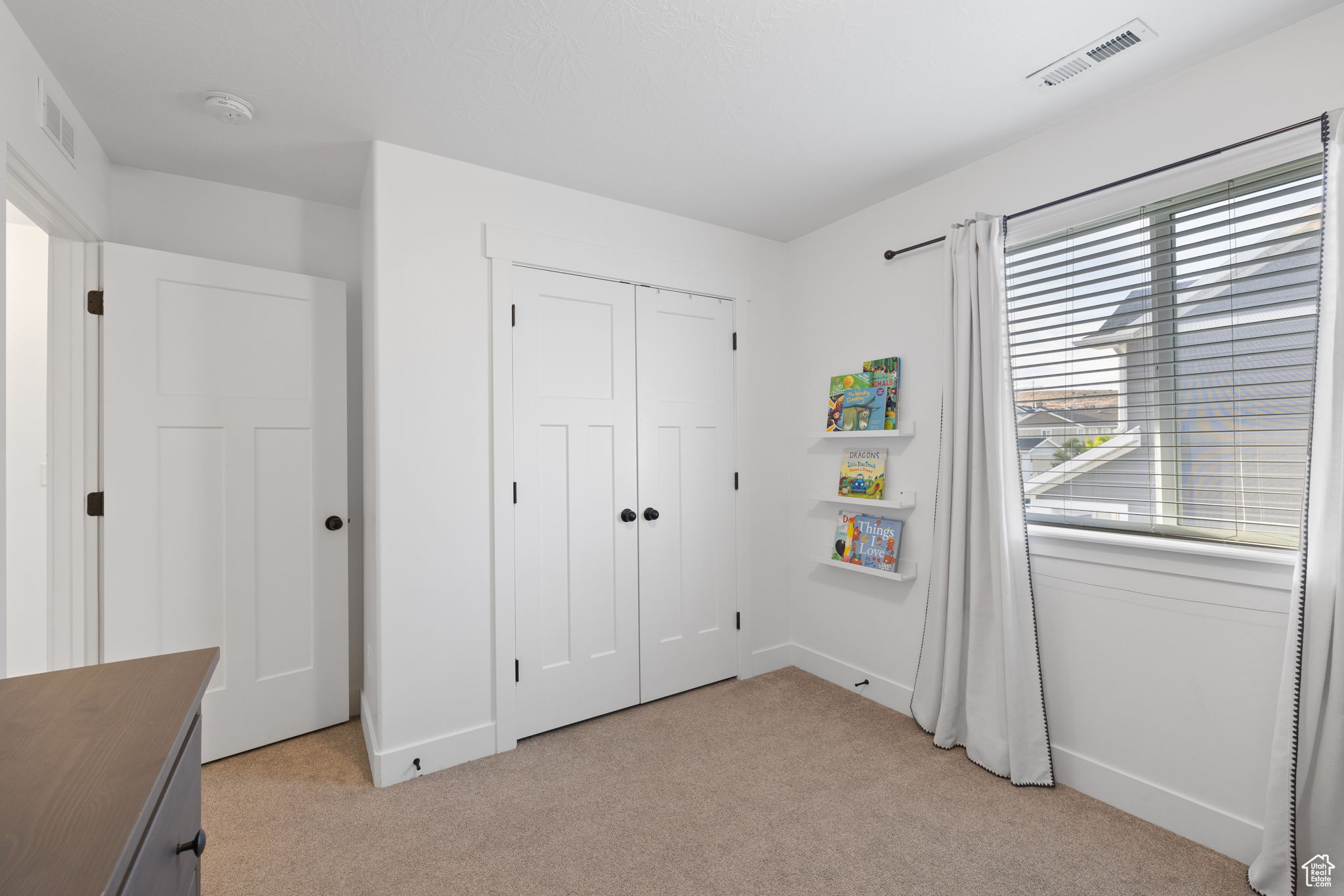 Unfurnished bedroom with a closet and light carpet