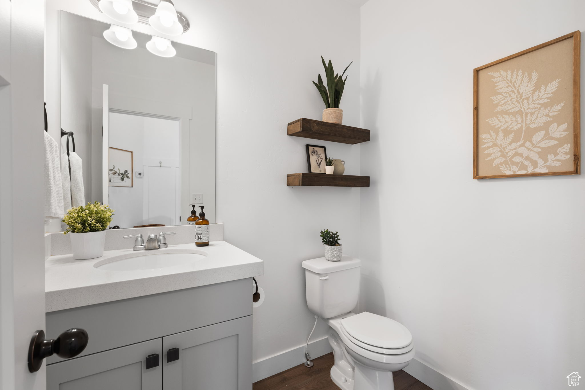 Bathroom featuring hardwood / wood-style flooring, vanity, and toilet