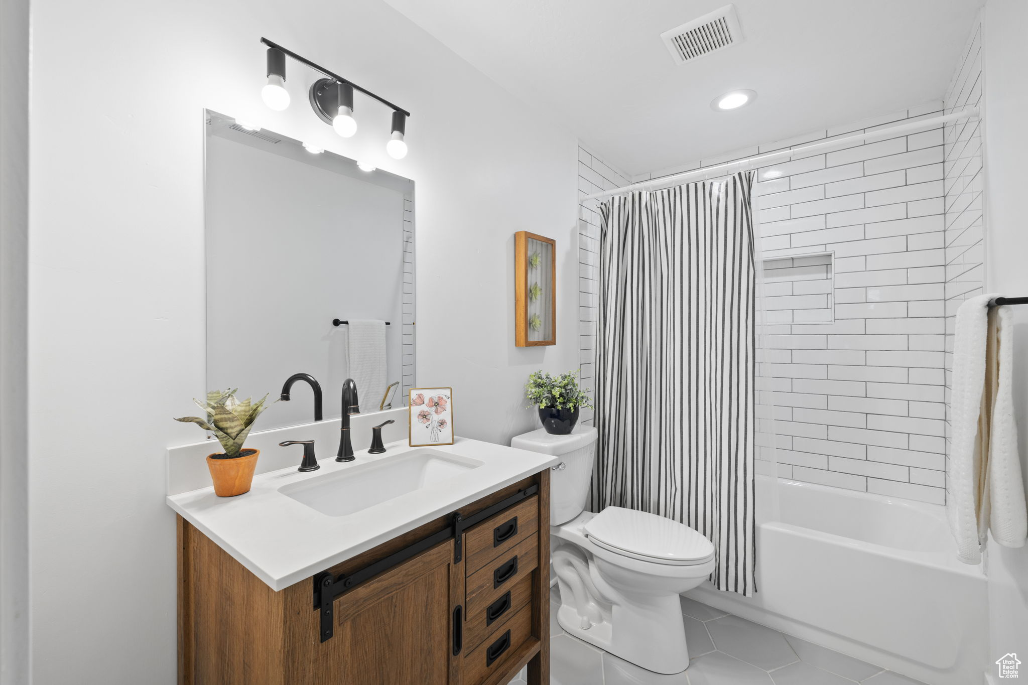 Full bathroom featuring tile flooring, vanity, toilet, and shower / tub combo